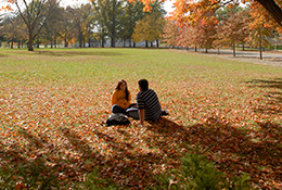 Two students sitting on the ground. Links to Beneficiary Designations